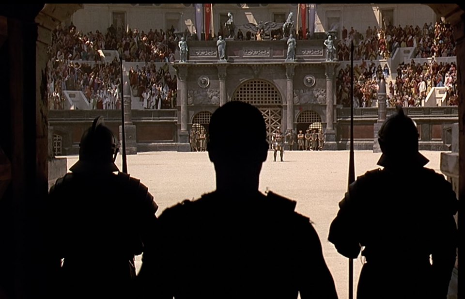 Gladiator reference frame from a shadowed entrance, with three silhouetted figures looking into the bright, crowded arena.